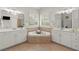 Luxurious main bathroom featuring dual sinks, vanity areas, a large tub, and tile flooring at 3749 Watkins Ne Pl, Brookhaven, GA 30319