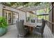 Enjoy outdoor dining beneath a charming pergola adorned with greenery and soft string lights on the deck at 3749 Watkins Ne Pl, Brookhaven, GA 30319