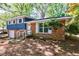 Charming brick and blue siding home with manicured front yard and inviting front porch at 5287 Chantilly Ter, Atlanta, GA 30349