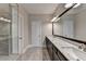Bathroom featuring a marble countertop, dual sinks, and glass-enclosed shower at 595 Broadview Ne Pl, Atlanta, GA 30324