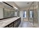 Bathroom featuring dual sinks, marble countertops, and a glass shower enclosure at 595 Broadview Ne Pl, Atlanta, GA 30324