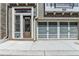 Townhouse featuring a contemporary garage door, brick facade, and convenient front-door entry at 595 Broadview Ne Pl, Atlanta, GA 30324