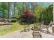 Landscaped backyard with stone patio, fire pit, and mature trees at 68 Highcrest Dr, Acworth, GA 30101