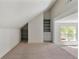 Carpeted bonus room with built-in shelves, storage, and natural light at 68 Highcrest Dr, Acworth, GA 30101