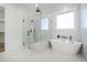 Bright bathroom featuring a glass shower, soaking tub, and marble-look tile at 876 Bramlett Shoals Rd, Lawrenceville, GA 30045