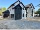 Elegant two-story home boasting a sleek black and white facade, arched entry, and attached garage at 876 Bramlett Shoals Rd, Lawrenceville, GA 30045