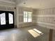 Open concept living room featuring tall windows, paneled walls, and a double door entry at 876 Bramlett Shoals Rd, Lawrenceville, GA 30045