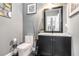 Well-lit bathroom featuring a black vanity, modern mirror, and toilet with black accents at 1837 Miramonte Way, Lawrenceville, GA 30045