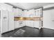 Well-lit kitchen with white cabinetry, stainless steel appliances, and dark tile flooring at 1837 Miramonte Way, Lawrenceville, GA 30045