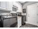 Laundry room with modern black appliances and bright white cabinets at 1837 Miramonte Way, Lawrenceville, GA 30045