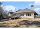 Charming home's rear exterior with a deck overlooking a well-manicured lawn and mature trees at 1837 Miramonte Way, Lawrenceville, GA 30045