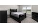 Bedroom featuring a black bedframe, gray carpet, and bright window at 3728 In Bloom Way, Auburn, GA 30011