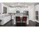 Modern kitchen with white cabinets, granite countertops, stainless steel appliances, and island seating at 3728 In Bloom Way, Auburn, GA 30011