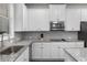 Bright kitchen boasts white cabinets, granite countertops, stainless steel appliances, and tile backsplash at 3728 In Bloom Way, Auburn, GA 30011
