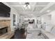 Bright open-concept living room leading into kitchen, with a coffered ceiling and stone fireplace at 3728 In Bloom Way, Auburn, GA 30011