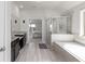 Expansive main bathroom featuring double vanity, soaking tub, and glass-enclosed shower at 3728 In Bloom Way, Auburn, GA 30011
