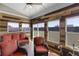 Bright sunroom filled with natural light, wood accents, comfortable seating, and outdoor views at 3728 In Bloom Way, Auburn, GA 30011