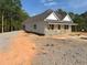 Side view of a bright, single-story home with a light exterior and well-defined roofline, amidst a natural landscape at 95 Rome St, Temple, GA 30179