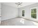 Bright bedroom with neutral carpet, a ceiling fan, and two windows with leafy views at 1998 Shalimar Ne Dr, Atlanta, GA 30345