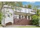 Two-story home featuring a metal roof, a wooden porch with a modern railing, and white siding at 1998 Shalimar Ne Dr, Atlanta, GA 30345