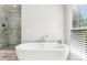Elegant main bathroom with marble-tiled shower, soaking tub, and lots of natural light at 1998 Shalimar Ne Dr, Atlanta, GA 30345