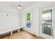 Mudroom with built-in bench seating, coat hooks, hardwood floors, and a window to the backyard at 1998 Shalimar Ne Dr, Atlanta, GA 30345
