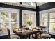 Dining room featuring a dark wood table, setting for four, and large windows with beautiful natural light at 2319 Lochinver Ln, Conyers, GA 30094