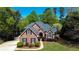 Elegant brick home with lush landscaping, mature trees, and a winding driveway, creating a tranquil and inviting ambiance at 2319 Lochinver Ln, Conyers, GA 30094
