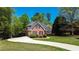 Lovely brick home with a curved driveway, lush landscaping, and mature trees, providing a peaceful and picturesque setting at 2319 Lochinver Ln, Conyers, GA 30094