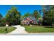 Inviting brick home boasts a winding driveway, lush lawn, mature trees, and a well-maintained landscape at 2319 Lochinver Ln, Conyers, GA 30094