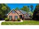 Charming brick home featuring manicured landscaping, black shutters, and an arched entryway, offering great curb appeal at 2319 Lochinver Ln, Conyers, GA 30094
