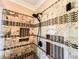 Close-up of a glass enclosed shower featuring decorative tile and built-in shelving at 2319 Lochinver Ln, Conyers, GA 30094