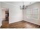 Open dining room featuring hardwood floors, modern chandelier, and a large window at 859 Walking Stick Trl, Auburn, GA 30011