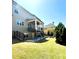 View of the backyard with covered patio, fire pit, lawn and green shrubs at 2671 Moon Chase Ln, Buford, GA 30519