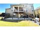 View of the backyard with multiple patio spaces, green lawn, stairs and covered patio at 2671 Moon Chase Ln, Buford, GA 30519