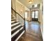 Foyer showcasing staircase, hardwood floors, decorative rug, and neutral walls at 2671 Moon Chase Ln, Buford, GA 30519