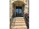 Close-up of the front door with stone facade, steps with iron railings, and a welcoming 'Blessed' sign at 2671 Moon Chase Ln, Buford, GA 30519