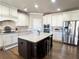 Kitchen featuring white cabinets, stainless appliances, granite countertops, and dark island with seating at 2671 Moon Chase Ln, Buford, GA 30519