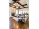 Open-concept living room featuring a stone fireplace, hardwood floors, coffered ceilings, and abundant natural light at 2671 Moon Chase Ln, Buford, GA 30519