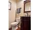 Elegant powder room with dark wood vanity, decorative mirror, and classic fixtures at 3315 Sardis Bend Dr, Buford, GA 30519