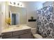 Well-lit bathroom features a single sink, decorative shelf, and floral shower curtain at 351 Senna St, Marietta, GA 30064