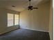 Large carpeted bedroom with ample natural light from two windows and a ceiling fan at 4071 River Rd, Ellenwood, GA 30294