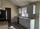 Well-lit kitchen with white cabinets, granite countertops, stainless steel appliances, and backyard access at 4071 River Rd, Ellenwood, GA 30294