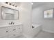 Bathroom featuring white cabinetry, modern fixtures, a soaking tub, and a decorative window at 813 Sandy Creek Rd, Fayetteville, GA 30214