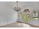Bright dining room with wainscotting, decorative windows, and a modern chandelier at 813 Sandy Creek Rd, Fayetteville, GA 30214
