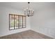 Dining room featuring wainscotting, a large window, and a modern chandelier at 813 Sandy Creek Rd, Fayetteville, GA 30214