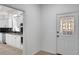 Entryway with a decorative glass front door and a glimpse into a kitchen with white cabinets at 813 Sandy Creek Rd, Fayetteville, GA 30214