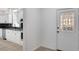 Well-lit kitchen is shown next to the entryway with decorative door in this open concept floor plan at 813 Sandy Creek Rd, Fayetteville, GA 30214