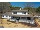 Two-story home featuring a welcoming porch, white siding, black shutters, and professionally landscaped front yard at 813 Sandy Creek Rd, Fayetteville, GA 30214