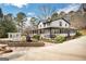 Beautiful two-story home with a wrap around porch, black shutters, white siding, and lush landscaping at 813 Sandy Creek Rd, Fayetteville, GA 30214